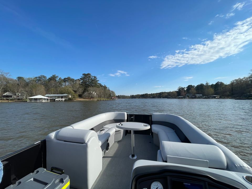 Front lounge seating of the Bentley Navigator 243 on open water under a blue sky