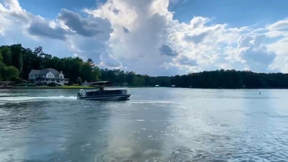 Opening frame of our Jackson Lake video: a boat cruising past a tree-lined shore under a cloudy sky